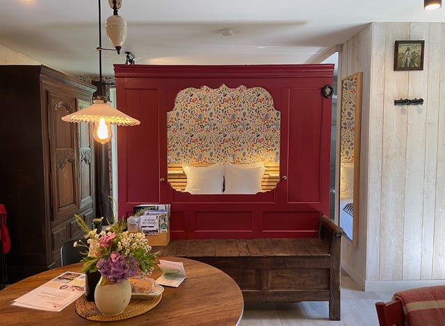 Le panneau de lit clos breton en rouge Farrow & Ball qui sépare l’espace jour et nuit dans le gîte pour deux personnes