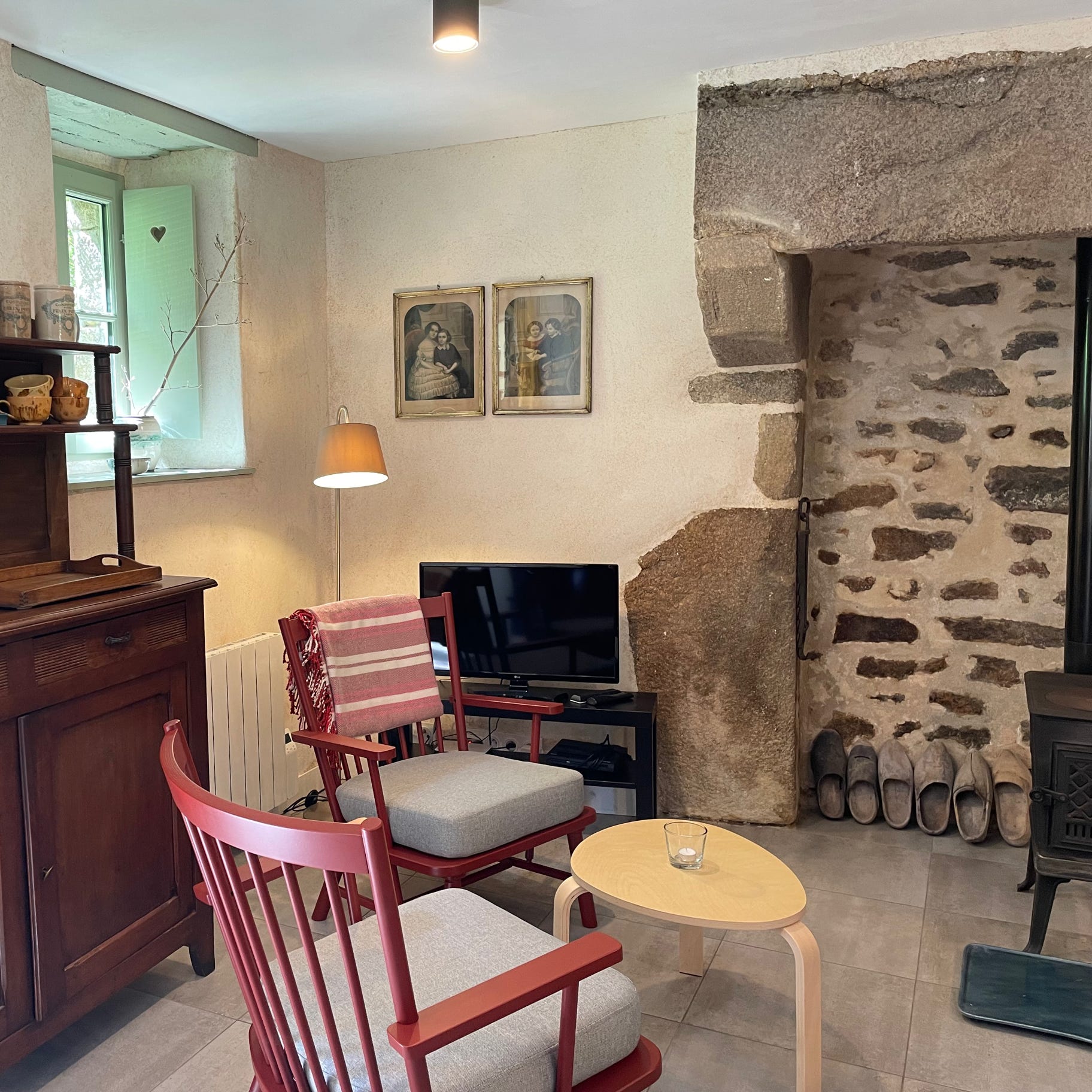 Poêle à bois scandinave Jøtul au salon du gîte cosy 3 étoiles La Maison du Four avec une isolation chaux-chanvre, anciennes lithographie, l'ancien et moderne se rencontre