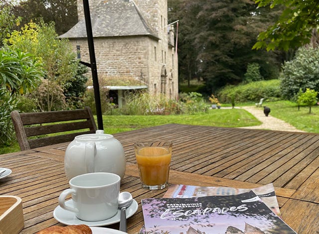 terrasse devant le gîte de charme pour trois avec une table et des chaises avec vue sur le Manoir et le parc