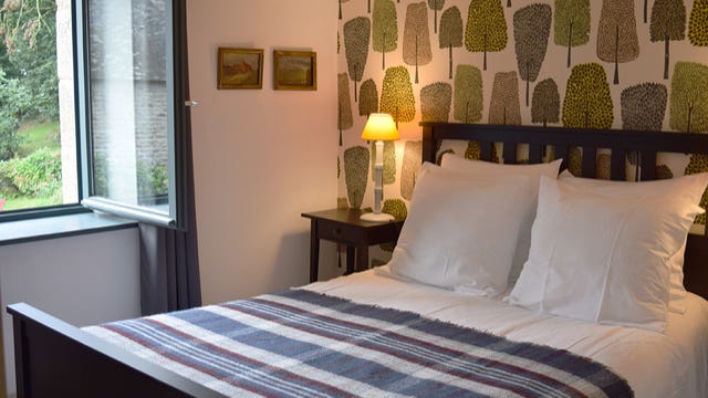 Chambre double dans le gîte Métairie du Manoir avec papier peint anglais vue sur le Manoir Renaissance et son parc au calme en pleine nature