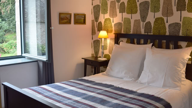 Chambre double dans le gîte Métairie du Manoir avec papier peint anglais vue sur le Manoir Renaissance et son parc au calme en pleine nature
